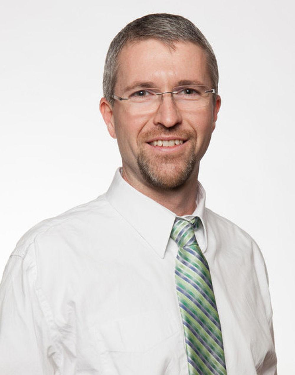 大卫·林德斯特伦穿着白衬衫和绿/蓝条纹领带的专业肖像. 